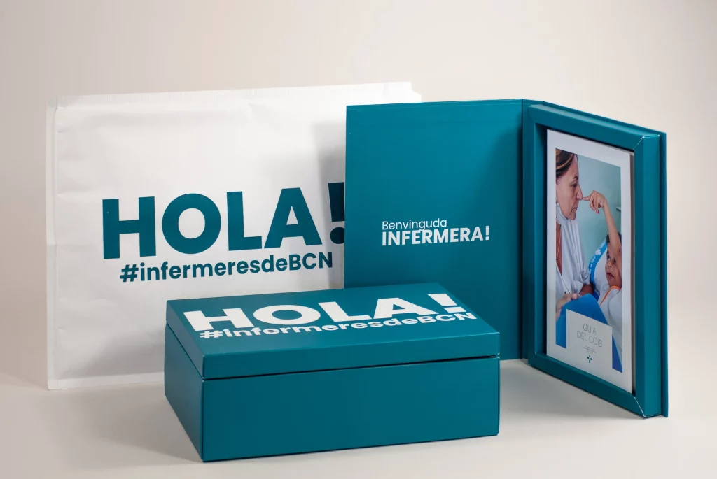 Caja del pack de bienvenida del COIB con un saludo 'HOLA!' y el hashtag #infermeresdeBCN, diseñada para dar la bienvenida a nuevos miembros del Col·legi d’Infermeres de Barcelona