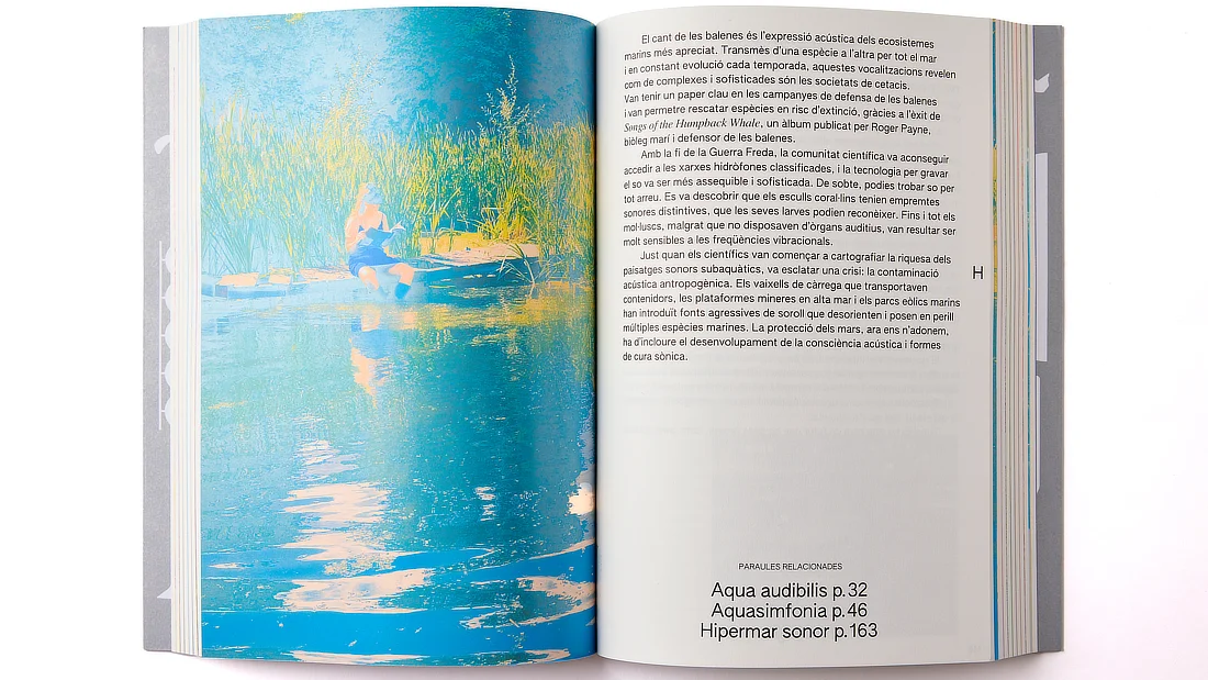Doble página del libro con texto en catalán y una imagen artística de una persona sentada junto al agua.