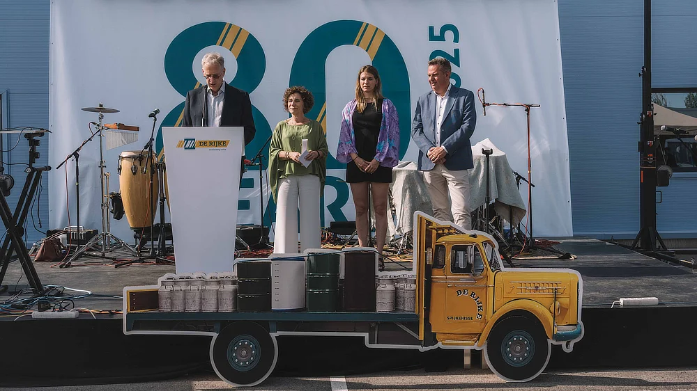 Scène avec décor de camion en carton et direction de De Rijke pendant les discours du 80e anniversaire.