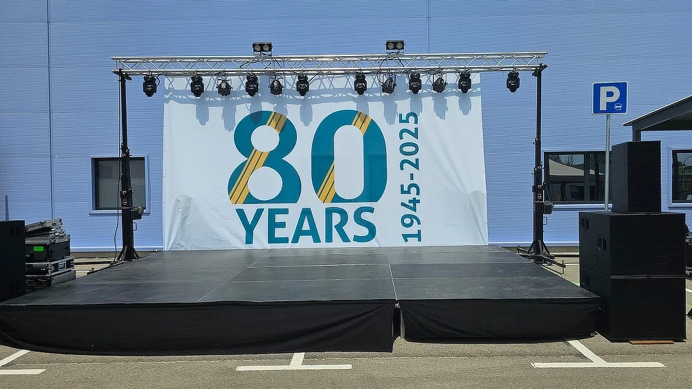Scène vide avec toile grand format célébrant les 80 ans de De Rijke, avant le début de l’événement.