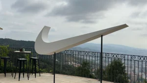 Vista de l'escultura del logotip Swoosh de Nike a gran escala “flotant” visualment, com un altre element de gran format, a l'esdeveniment del Just Do It Day.