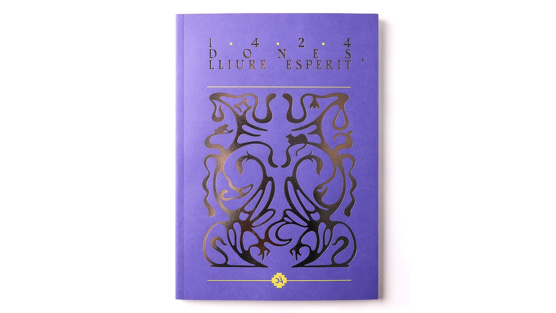 Primer plano del detalle en blanco y dorado de la portada del libro, resaltando el título y los acabados especiales.