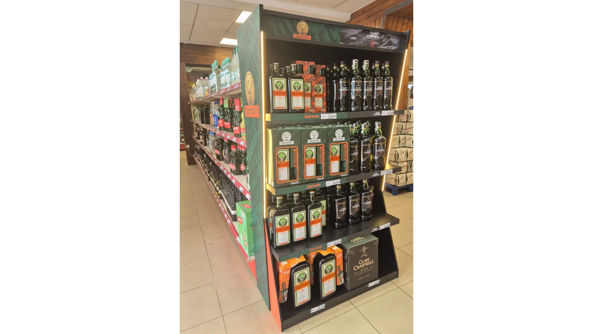 Cabecera de PLV para Great Spirit con botellas de Jägermeister y Clan Campbell, iluminación LED lateral y estructura renovable en madera dentro de un supermercado.