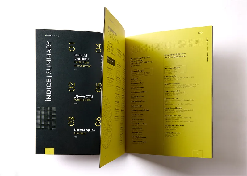 Páginas interiores de una memoria anual abiertas, mostrando un índice bilingüe y secciones corporativas diseñadas con una maquetación moderna en tonos negros y amarillos.