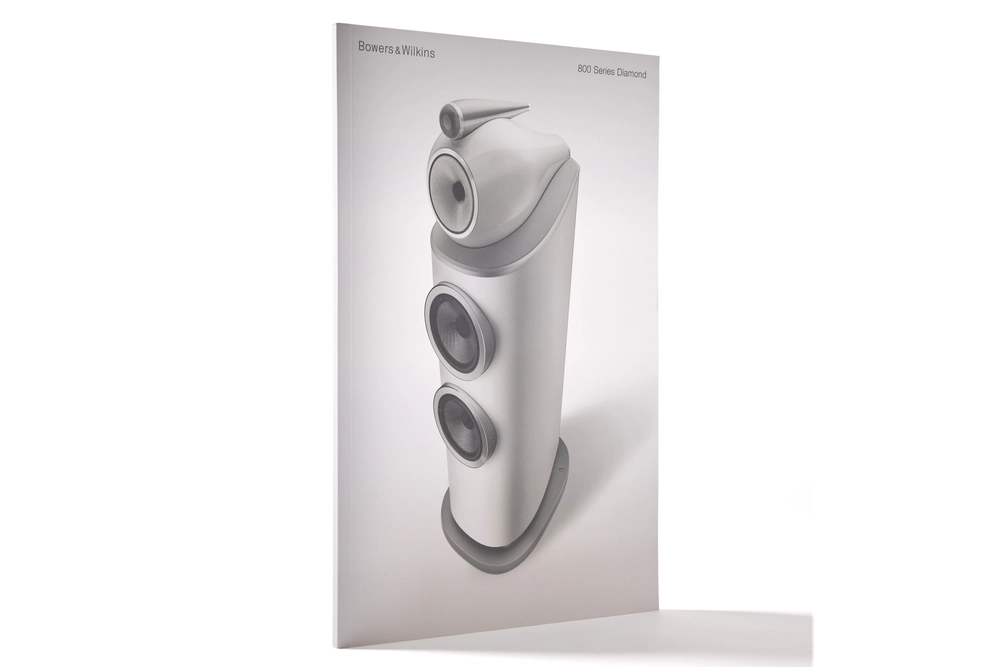 Detalle de la portada del catálogo Bowers & Wilkins mostrando la textura del papel premium y la nitidez de la impresión del logotipo.