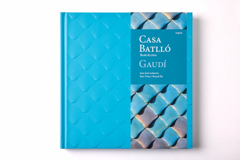Portada del libro de arte Casa Batlló edición English, con una faja azul oscuro que integra una fotografía detallada de azulejos arquitectónicos de Gaudí.