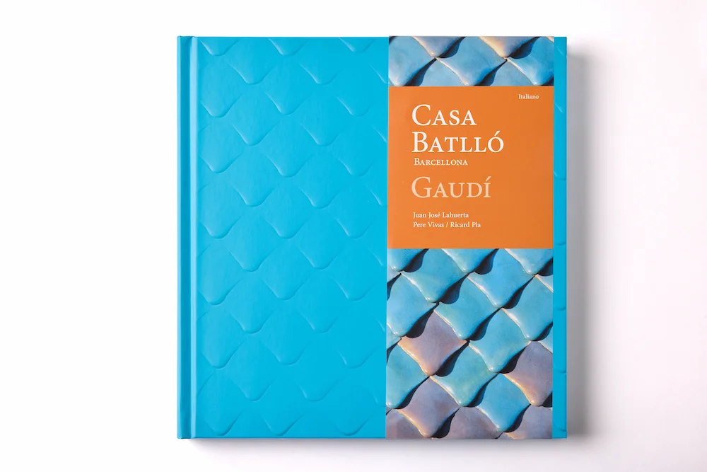 Edición italiana del libro de arte Casa Batlló, que incorpora una faja naranja con el título y detalles gráficos sobre la textura tridimensional de la obra.