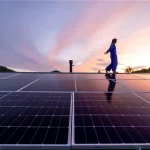 Hilera de paneles solares fotovoltaicos instalados sobre estructuras metálicas en una azotea, bajo un cielo despejado, ejemplificando acciones reales de sostenibilidad.
