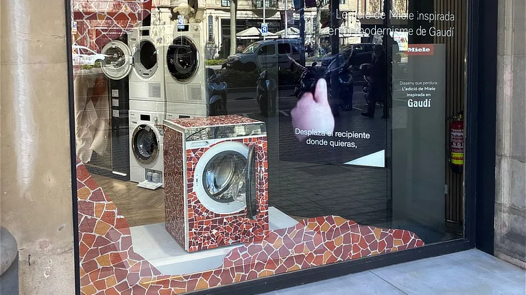 Miele washing machine with decorative vinyl inspired by Gaudí's mosaic located in a shop window with communication graphics on energy saving.