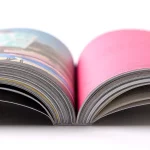 Detalle en primer plano de la encuadernación técnica de un libro de fotografía profesional abierto, mostrando el lomo y el grosor de las páginas impresas.